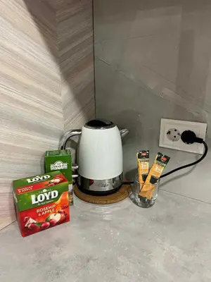a coffee maker next to a box of chips and a box of candy at Svečių namelis in Kaunas