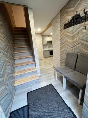 a room with a staircase with a bench and a rug at Svečių namelis in Kaunas