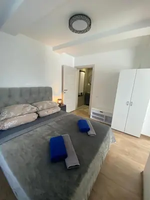 a bedroom with a large bed with blue towels on it at Centro apartments Rokiškis in Rokiškis
