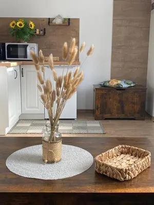 a room with a table with a vase and a basket at Centro apartments Rokiškis in Rokiškis