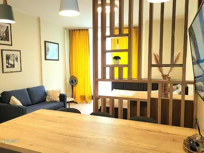 a living room with a table and a couch at HaPPy iNN LUX Old Town Studio, Self Check in, Parking in Vilnius