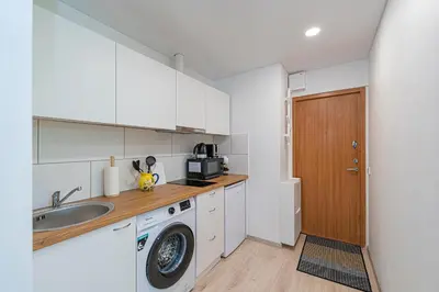 a kitchen with a sink and a washing machine at Partizanų studio apartment #1 by Polo Apartments in Kaunas