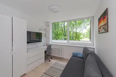 a living room with a couch and a desk and a tv at Partizanų studio apartment #1 by Polo Apartments in Kaunas