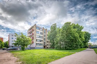 an apartment building with a green lawn in front of it at Partizanų studio apartment #1 by Polo Apartments in Kaunas
