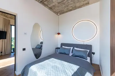 a bedroom with two mirrors above a bed at Panoramic View 1 BD Apartment by Domvia in Kaunas