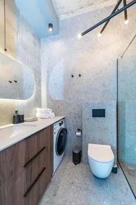 a bathroom with a washing machine and a toilet at Panoramic View 1 BD Apartment by Domvia in Kaunas