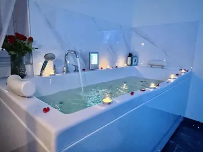 a bathroom with a tub with candles in it at Ž Šančių- Apartamentai in Kaunas