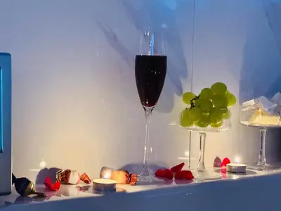 a glass of wine next to a bunch of green grapes at Ž Šančių- Apartamentai in Kaunas