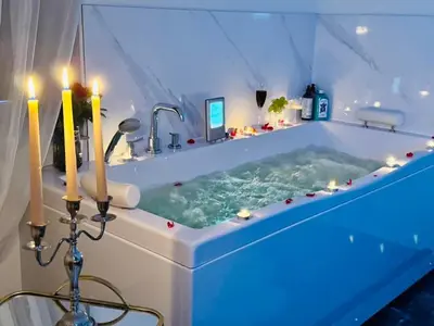 a bathroom with a tub with candles in it at Ž Šančių- Apartamentai in Kaunas
