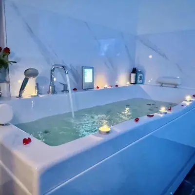 a bathroom with a tub with candles in it at Ž Šančių- Apartamentai in Kaunas