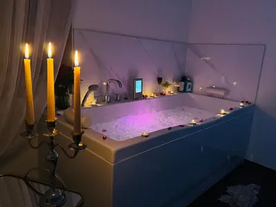 a bathroom with a tub with candles in it at Ž Šančių- Apartamentai in Kaunas