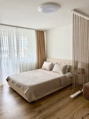 a bedroom with a large bed in front of a window at Liepų Apartamentai in Molėtai