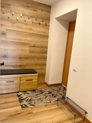a room with a wooden wall with a dresser at Liepų Apartamentai in Molėtai