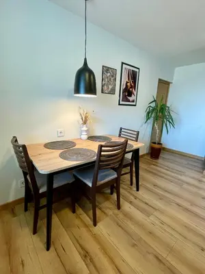 a dining room with a wooden table and chairs at Liepų Apartamentai in Molėtai