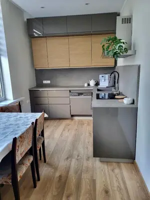 a kitchen with a counter and a table with chairs at Central Family Apt 70 m2 with free Parking & Private Entrance in Druskininkai