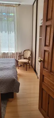 a bedroom with a bed and a chair and a window at Central Family Apt 70 m2 with free Parking & Private Entrance in Druskininkai