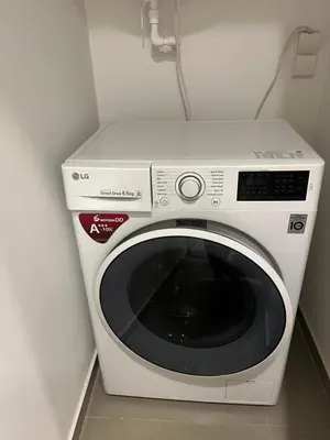 a white washing machine in a corner of a room at Central Family Apt 70 m2 with free Parking & Private Entrance in Druskininkai
