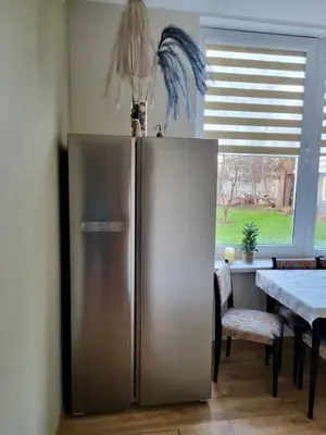 a stainless steel refrigerator in a kitchen with a table at Central Family Apt 70 m2 with free Parking & Private Entrance in Druskininkai