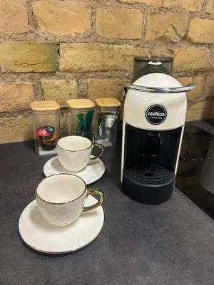 two cups on plates next to a coffee maker at Green Bridge Studio in Vilnius