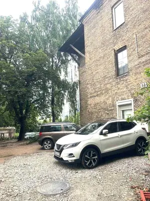 two cars parked in front of a brick building at Green Bridge Studio in Vilnius