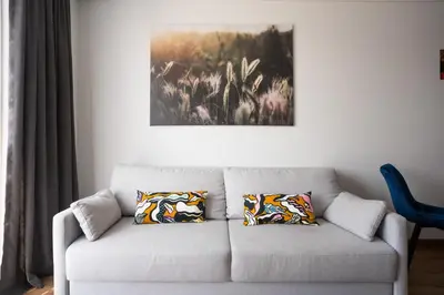 a living room with a couch with two pillows at Lazdyneliu Vingis, free underground parking, long stays welcome in Vilnius
