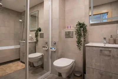 a bathroom with a toilet and a shower and a sink at Lazdyneliu Vingis, free underground parking, long stays welcome in Vilnius