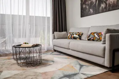a living room with a couch and a table at Lazdyneliu Vingis, free underground parking, long stays welcome in Vilnius