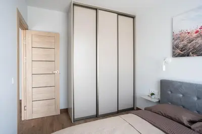 a bedroom with white walls and a bed with glass doors at Lazdyneliu Vingis, free underground parking, long stays welcome in Vilnius