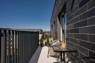 a balcony with a table and chairs on a building at Lazdyneliu Vingis, free underground parking, long stays welcome in Vilnius