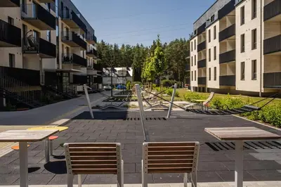 a courtyard with two tables and chairs and buildings at Home sweet home, cozy apartments, free underground parking, long stays welcome in Vilnius