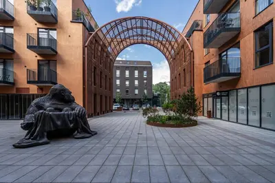 a statue of a man sitting on a bench in front of a building at Paupys lofts in Vilnius