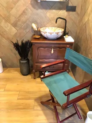 a bathroom with a chair and a bowl on a table at Boutique Studija Žibutė in Panevėžys