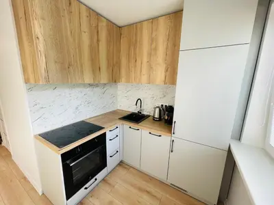 a small kitchen with white cabinets and a stove at LilHouse Apartment in Siauliai Center in Šiauliai