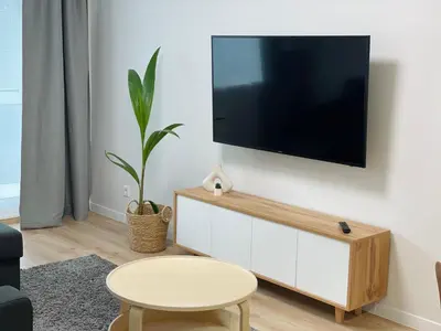 a living room with a flat screen tv on a wall at LilHouse Apartment in Siauliai Center in Šiauliai