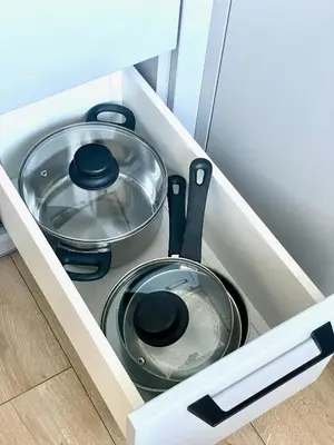 a kitchen drawer with two pans and a pot at LilHouse Apartment in Siauliai Center in Šiauliai