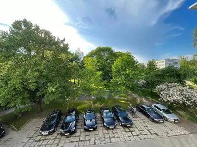 a group of cars parked in a parking lot at LilHouse Apartment in Siauliai Center in Šiauliai