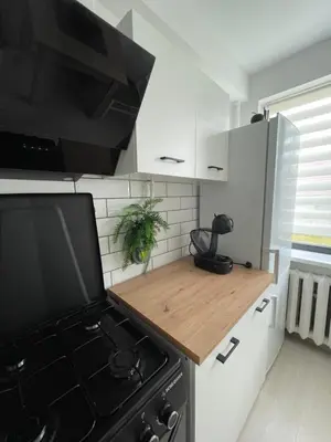 a kitchen with a black stove and a microwave at Radvilų apartamentai in Radviliškis
