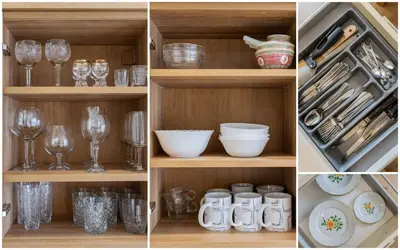 a cabinet with glasses and dishes and wine glasses at E D Arena View Apartment in Šiauliai