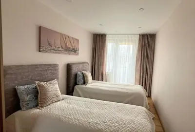 a bedroom with two beds and a window at E D Arena View Apartment in Šiauliai