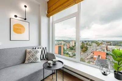 a living room with a couch and a large window at Vega Self Checkin in Vilnius