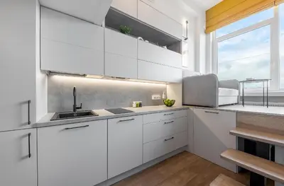 a white kitchen with a sink and a window at Vega Self Checkin in Vilnius