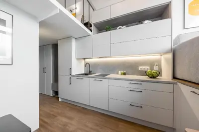 a kitchen with white cabinets and a sink at Vega Self Checkin in Vilnius