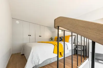 a bedroom with a bed with a yellow blanket at Vega Self Checkin in Vilnius