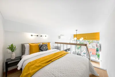 a bedroom with a bed with a yellow blanket at Vega Self Checkin in Vilnius