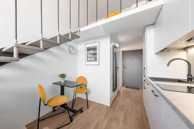 a kitchen with a small table and two chairs at Vega Self Checkin in Vilnius