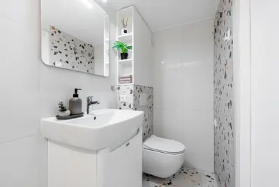 a white bathroom with a sink and a toilet at Vega Self Checkin in Vilnius