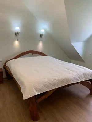 a bed in a room with two lights on the wall at Green House in Ramučiai