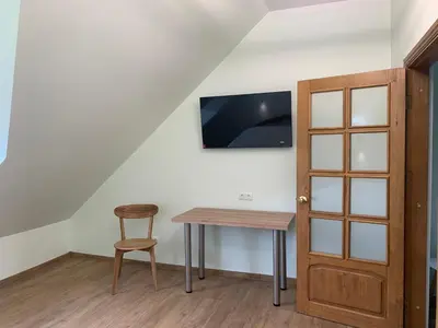 a room with a table and a chair and a tv at Green House in Ramučiai