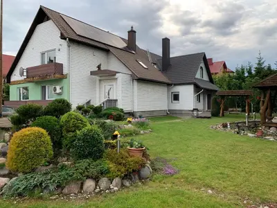 a house with a yard with flowers and plants at Green House in Ramučiai