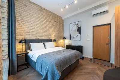 a bedroom with a bed and a brick wall at Art Boutique I Old Town Apartments w-AC I cohost in Vilnius